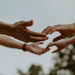 Eine Gruppe von Menschen streckt ihre Hände aus