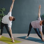 Paar praktiziert Yoga in einem modernen Raum