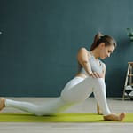 Frau dehnt sich auf der Yogamatte drinnen